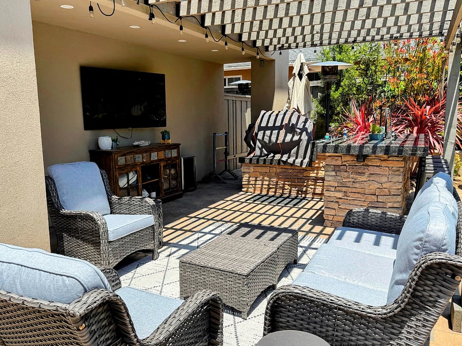 Outdoor seating with kitchen and smart TV.