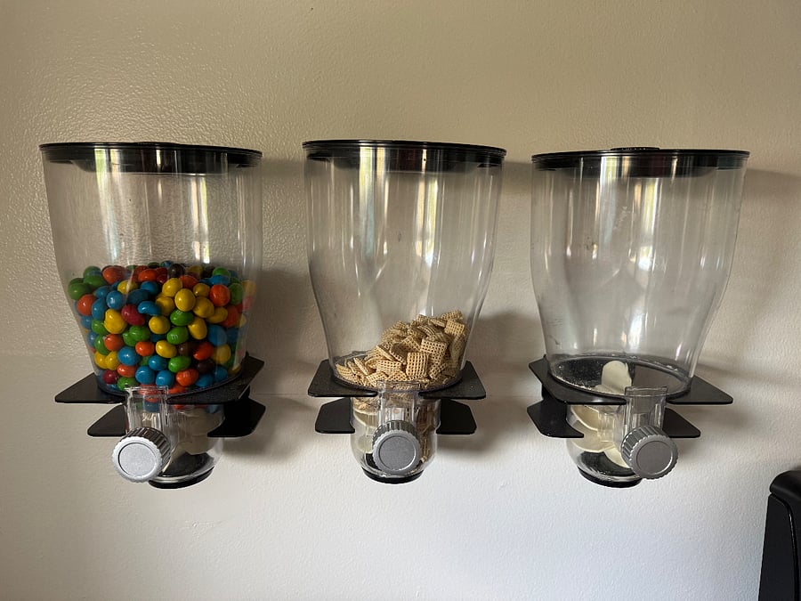 Mounted snack/cereal dispensers are located in the kitchen. You may request that the peanut M&Ms be removed or be available for consumption. The other two dispensers will be empty.