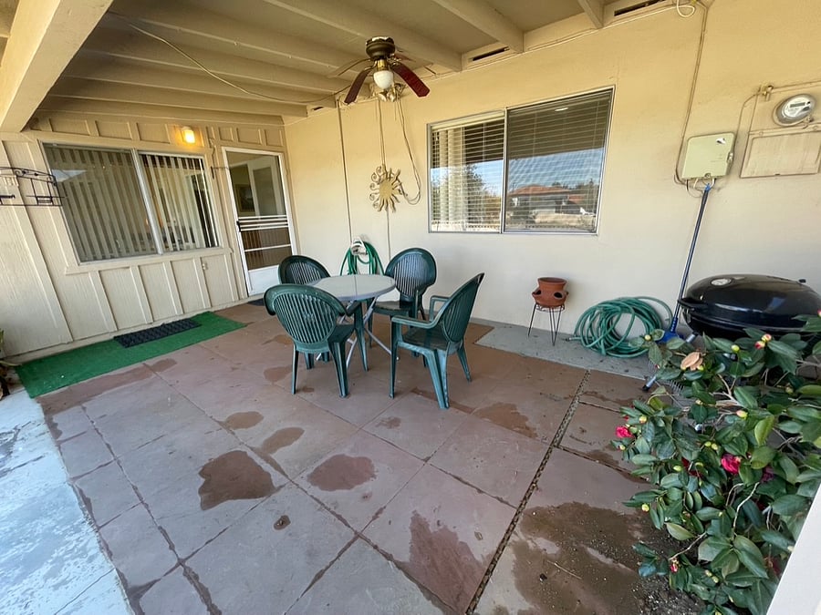 The covered patio offers a shady nook for outdoor dining.