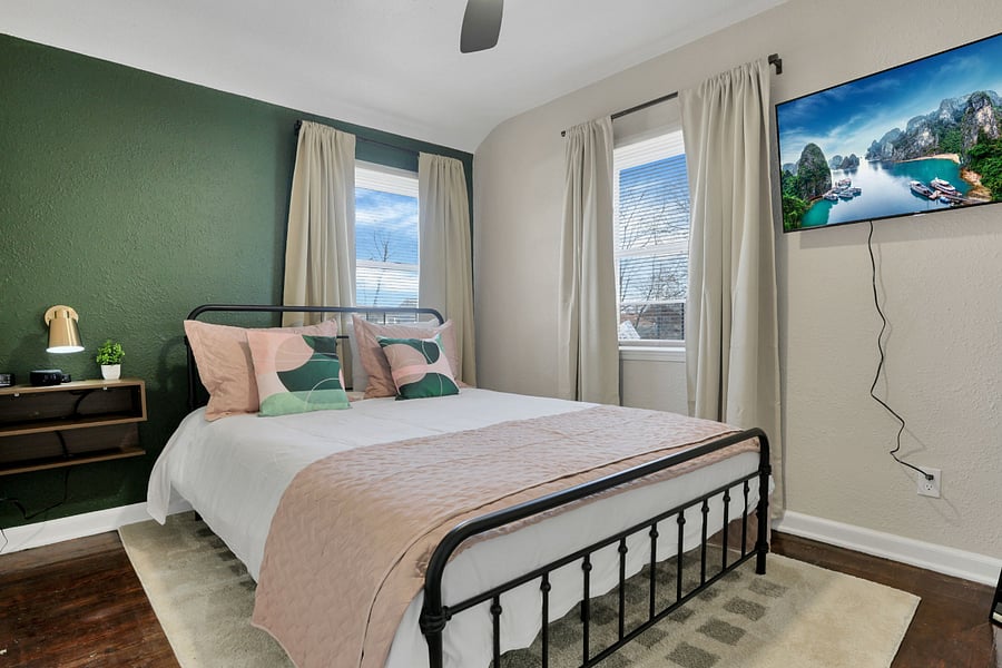 The "green" bedroom with smart tv, blackout drapes, and white noise machine.