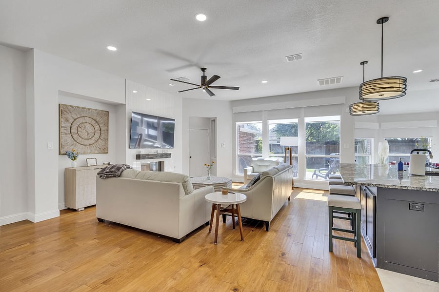 All leather furniture in a large family room, open to the kitchen and bar seating for 4. Blinds along the back windows are remote control-operated. Fireplace and 75" Smart TV.