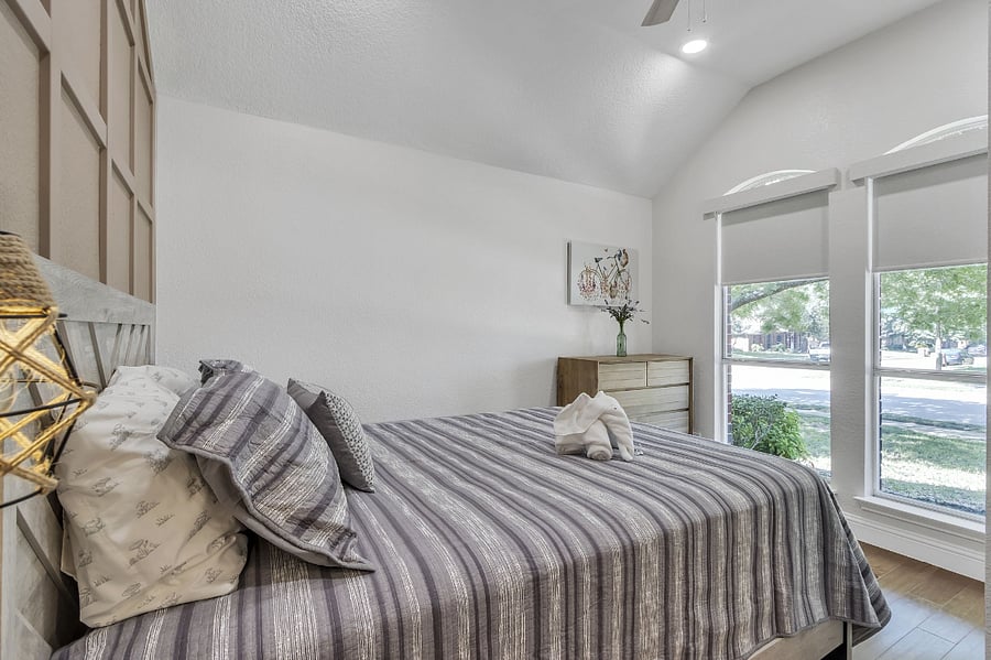 3rd bedroom has a queen bed, side tables, a front view with blackout blinds, a ceiling fan, a dresser, and a closet.