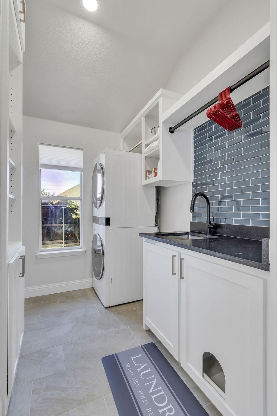 Large laundry room and pantry space off the kitchen. LG washer and dryer with laundry sink and storage