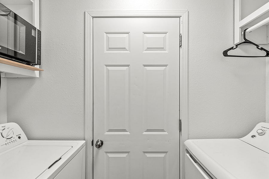 Washer and dryer located off kitchen. Microwave above washer. Door pictured is to the 3rd bedroom.