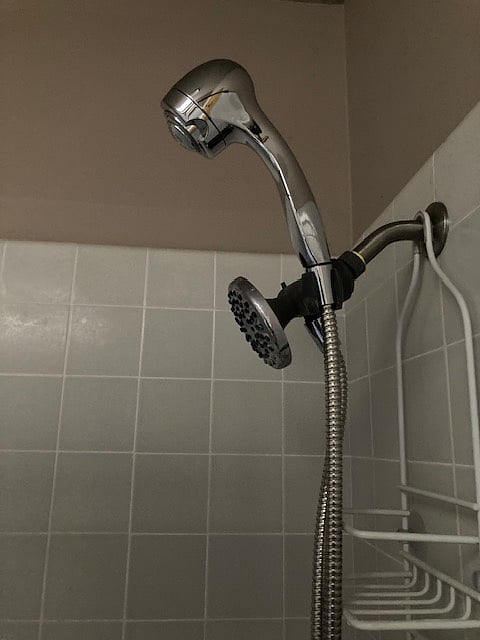 shared bathroom tiled bathtub with hand held shower option