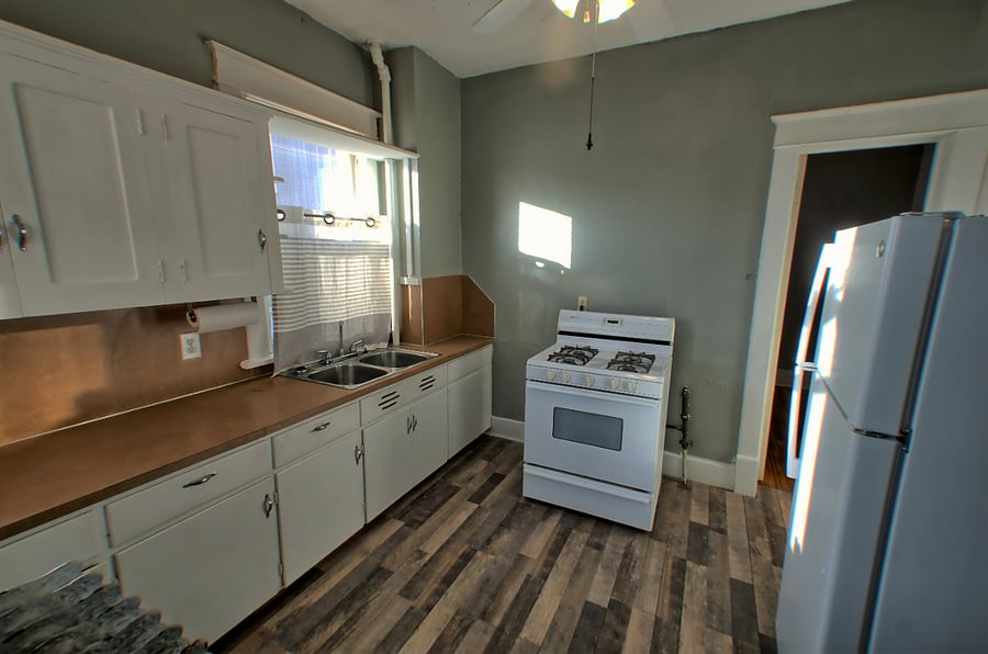 Entry door you see goes to bedroom. Ceiling fan, stackable full size washer and dryer behind the photographer with an outside door to back parking area.