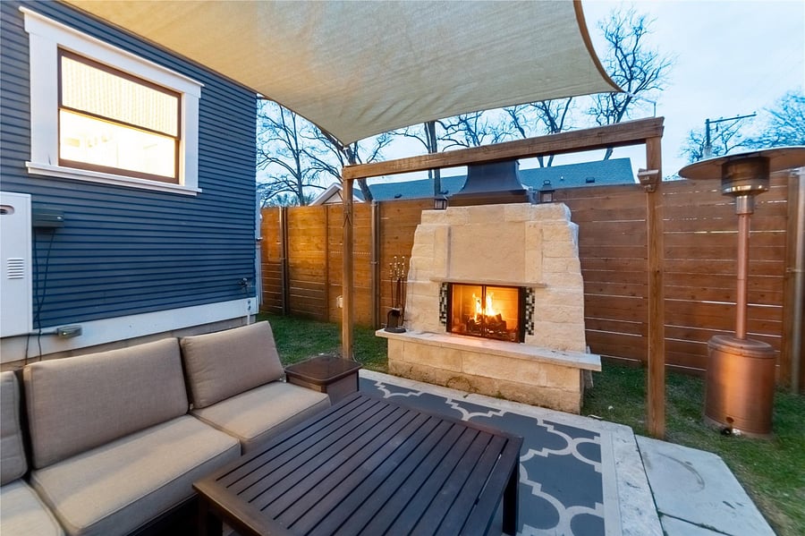 Cozy up in front of this backyard fireplace with a glass of wine.
