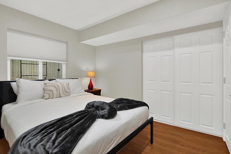 The lower level bedroom comes with a queen size bed, Smart TV, bedside drawers with a light and device outlet. It too has hotel style bedding, a ceiling fan, and a bedside cabinet for storage.