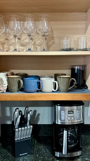 Coffee cups above the coffee maker- as it should be. Above you'll find the adult beverage glasses.