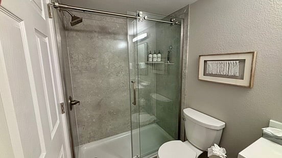 The main floor bath was fully remodeled with a surround shower and glass barn doors.
