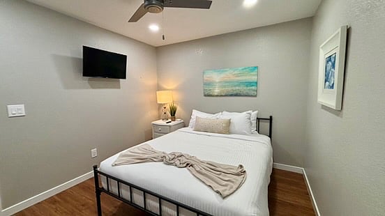 The second bedroom on the main floor also has The first bedroom on the main floor comes with a queen size bed, Smart TV, bedside drawers with a light and device outlet. Each bedroom is equipped with a ceiling fan for better sleep.