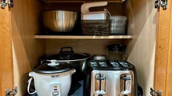 Small appliances are tucked away in the cabinet.