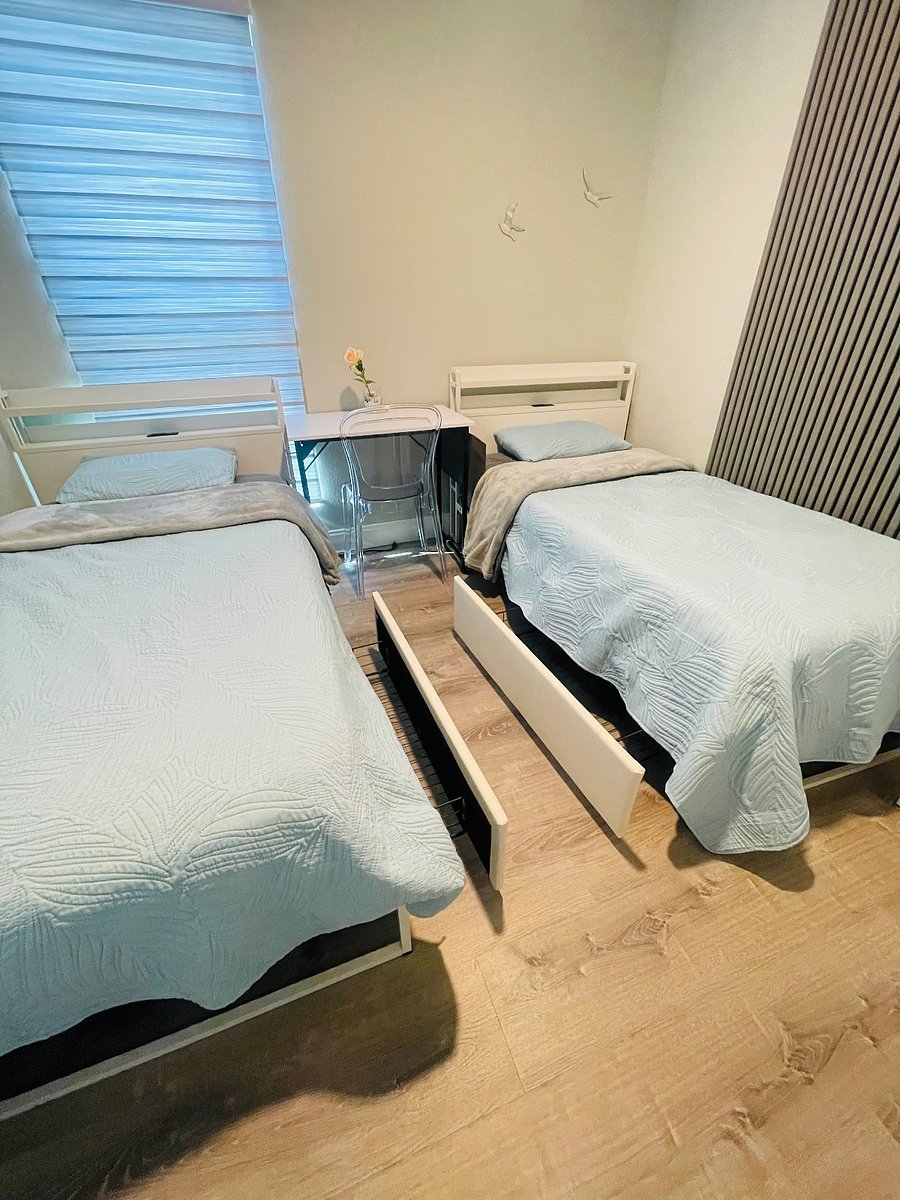 Twin beds with extra storage, electric outlets, and USB ports. 
