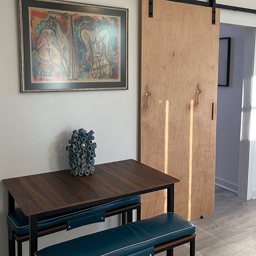 Dining table with benches. Showing sliding barn door to bedroom