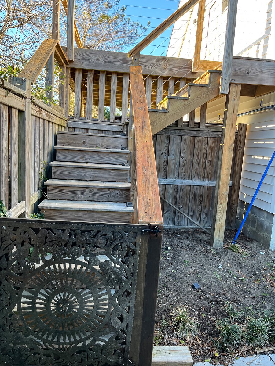 Gated stairs in pool area that go up to apartment.