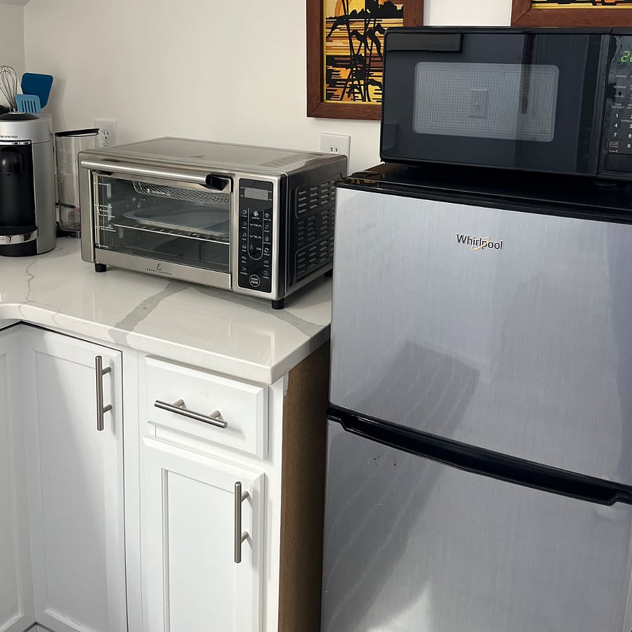 Apartment refrigerator, microwave, Nespresso and frother, Air Fryer/Toaster Oven combo. Electric skillet in cabinet.