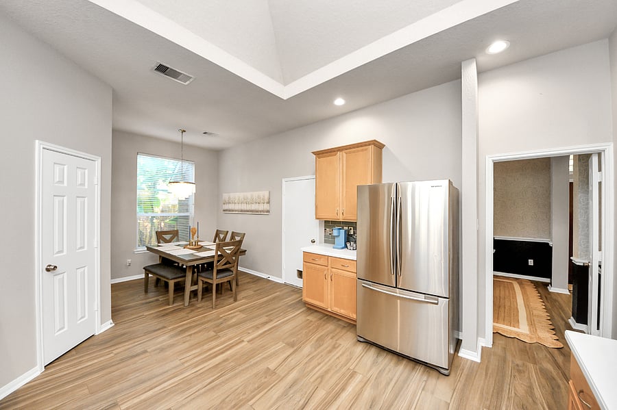 Large kitchen stocked with plates, bowls, cups, basic cookware, bakeware and Keurig. Table that holds 6 people.