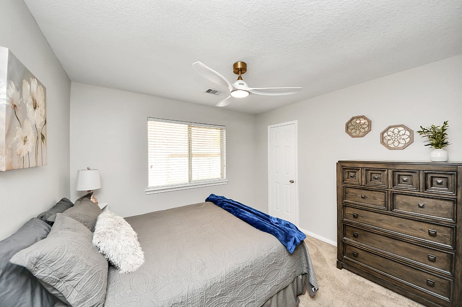 Guest bedroom with Queen size bed, ceiling fan and dresser.