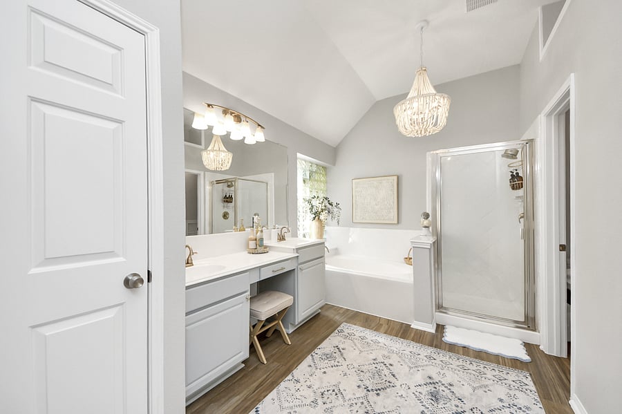 Dual vanity sink with makeup sitting area, updated light fixture, fresh paint and soaking tub with stand alone shower.