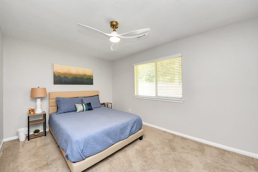Guest bedroom with Queen size bed, ceiling fan and TV.