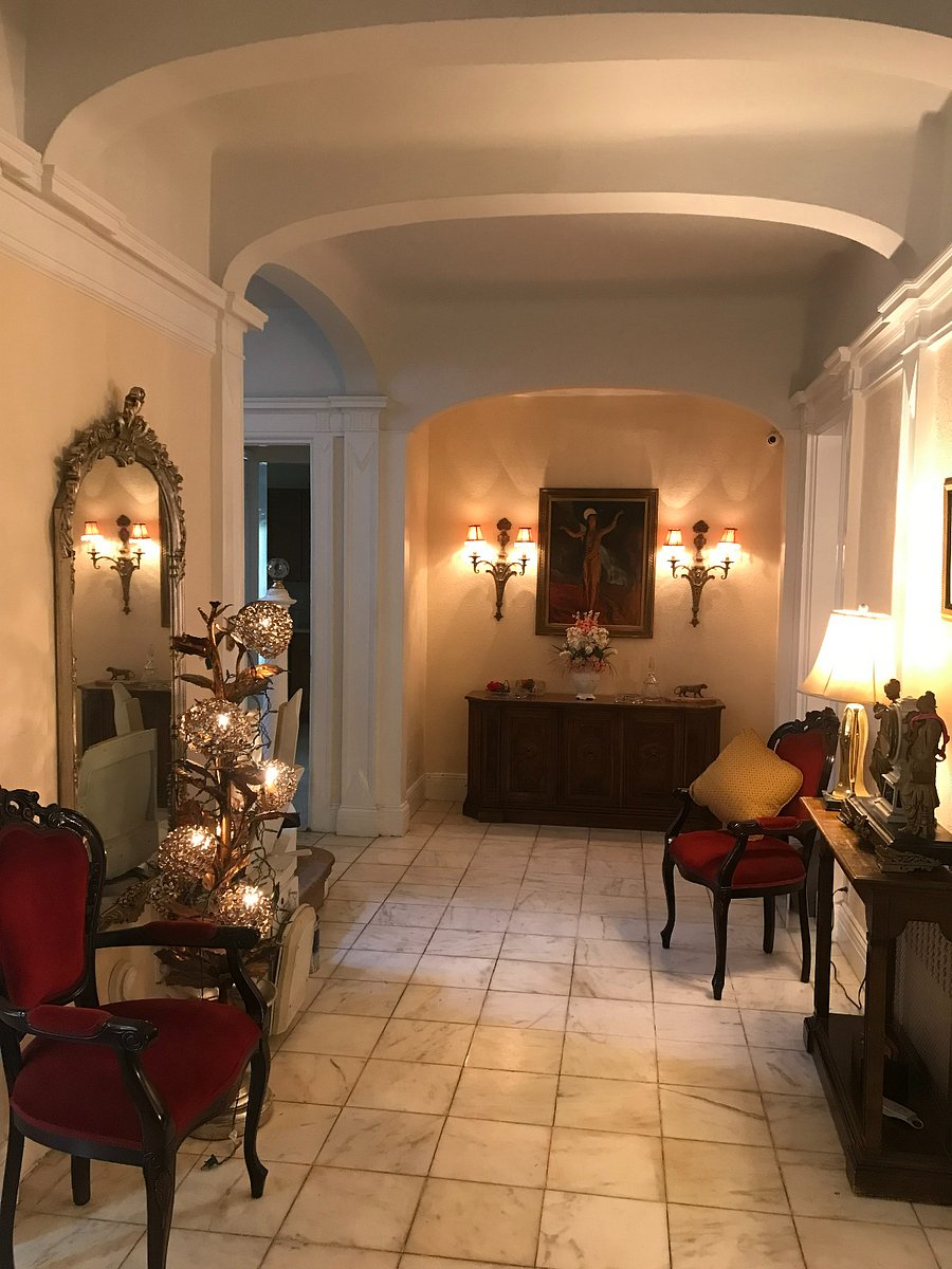 Main entry hall, 1st floor, more easy to appreciate after opening the inside glass doors.
Not visible behind the flowered floor lamp is an Acorn chairlift for handicap access to the second floor in working order.