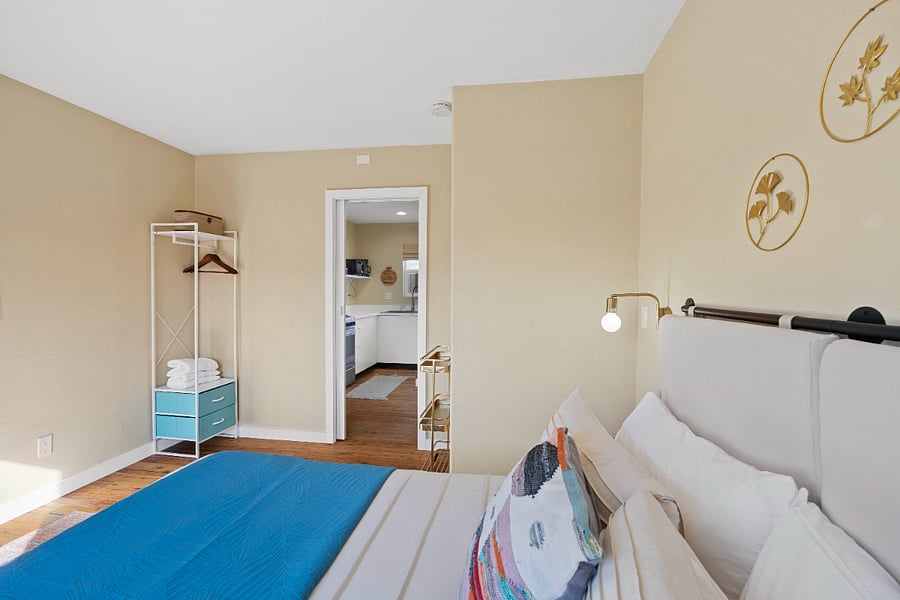 Bedroom with Queen bed, clothing organizer, and artful vibes.