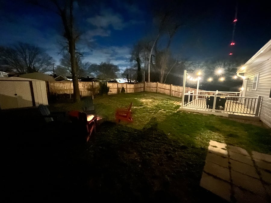 Enjoy time outdoors with a beautifully lighted backyard, complete with charming string lights for a magical evening atmosphere.