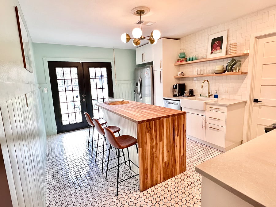 View of the kitchen, fridge, sink, island, and back door