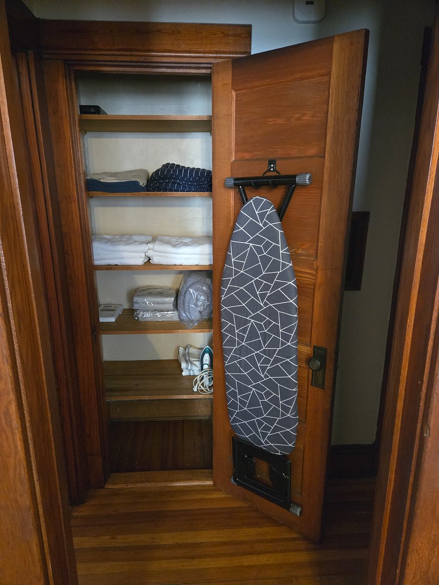 Hallway closet between Bedrooms leading to Bathroom with Linens, Towels, Iron and Ironing Board
