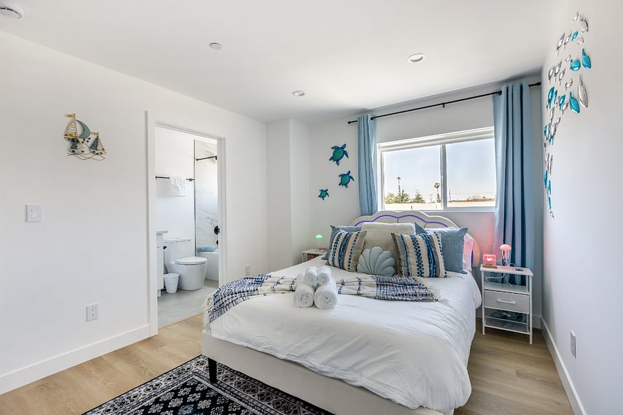 Ocean-Inspired Bedroom with Private Bath & Natural Light
Step into this serene, sea-themed sanctuary, where calm colors and thoughtful details create the perfect coastal escape. This bedroom features a plush queen bed with soft, ocean-toned linens and charming nautical dcorincluding playful sea turtles and a 3D fish school wall art. A large window fills the space with natural light, while blackout curtains ensure restful sleep.

Enjoy the convenience of a modern en-suite bathroom with marble-style tile and a rain showerheadperfect for relaxing after a day out in LA. The room also includes bedside tables, cozy throws, and towels folded hotel-style for your arrival.

Ideal for families, couples, or professionals, this bedroom is a peaceful retreat in a brand-new construction home.