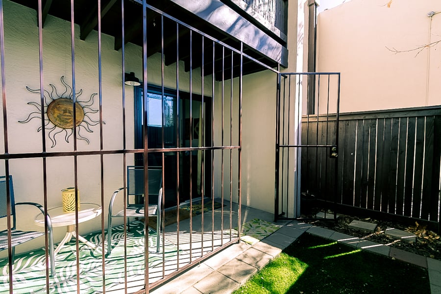 Private patio with green space and shade tree.