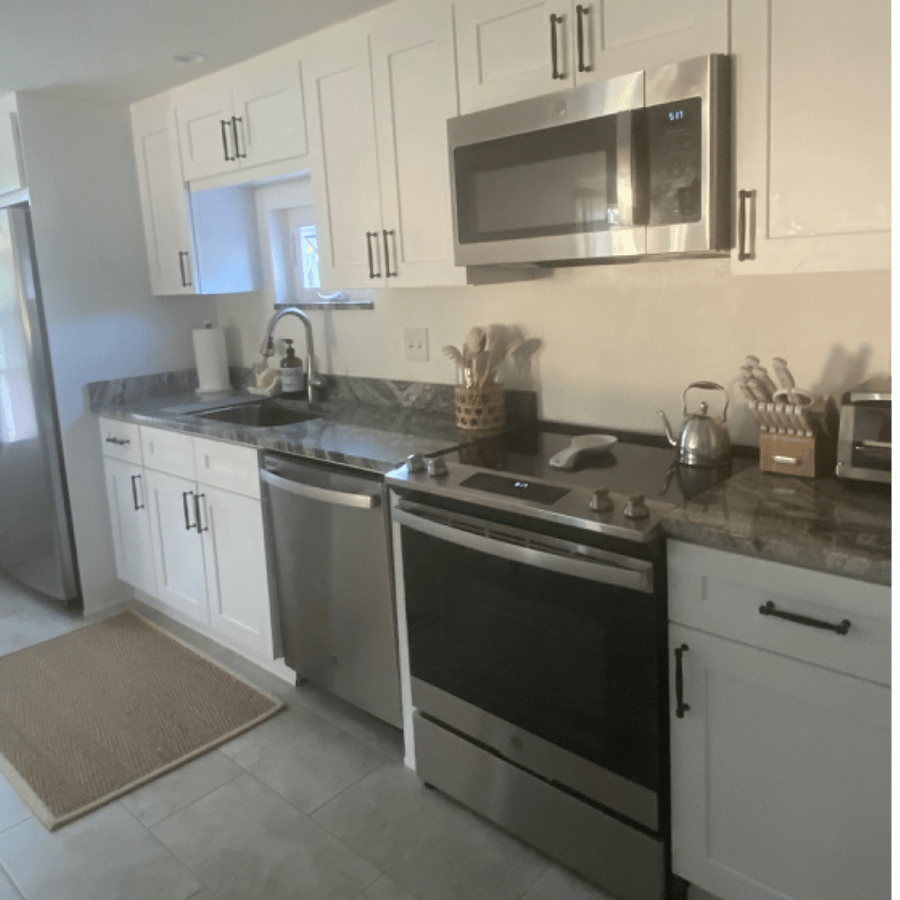 Luxury Kitchen with high end stainless refrigerator with water and ice maker, dishwasher and stove with ceramic cooktop, built in microwave, granite counters, farmhouse sink with sprayer.