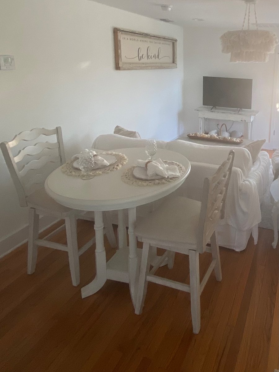 Counter height wooden dining table with comfortable ladder back with cushion seats.