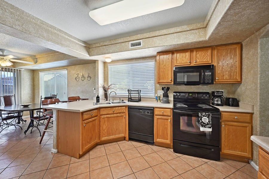 View of cooking space, cabinets, sink, dishwasher, stove, microwave, and some kitchen appliances.