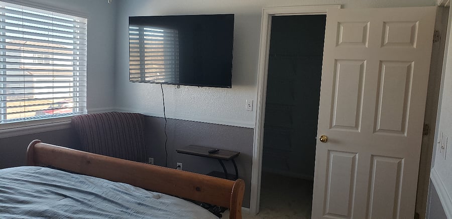 Main bedroom.  View to walk-in closet, TV, and the hallway.