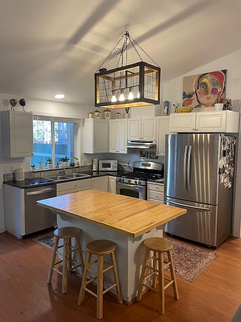 Open floor plan kitchen featuring a gas stove, fully stocked with cooking essentials and more.