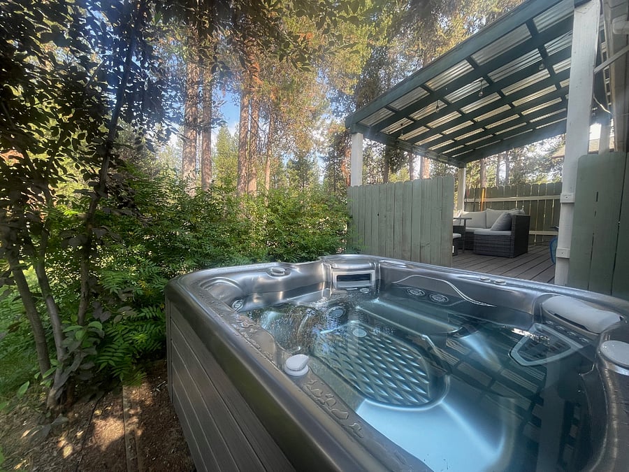 Serene backyard featuring a hot tub, ideal for relaxation and nighttime stargazing.