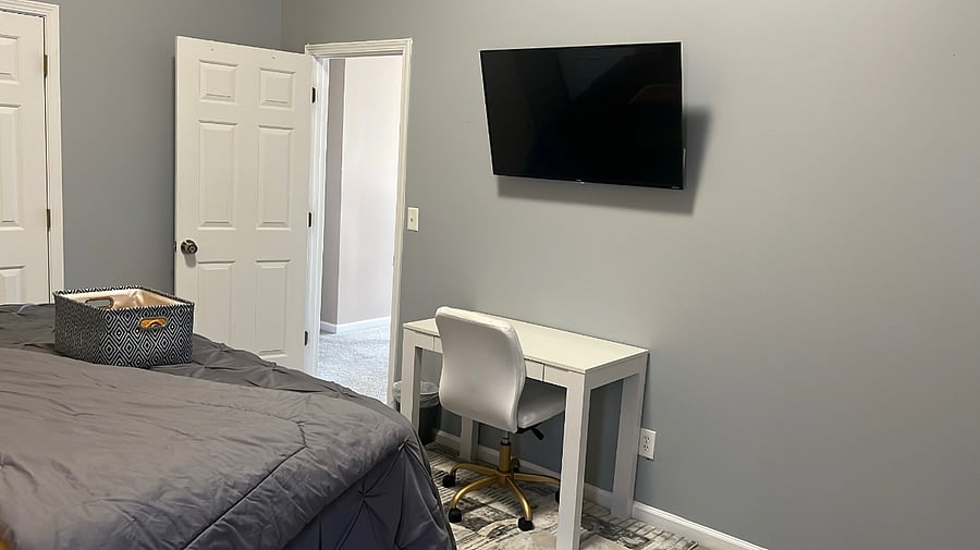 Guest bedroom-King sized bed, desk, smart TV, futon couch, laundry basket, ironing board, iron, dresser, towels & toiletries.