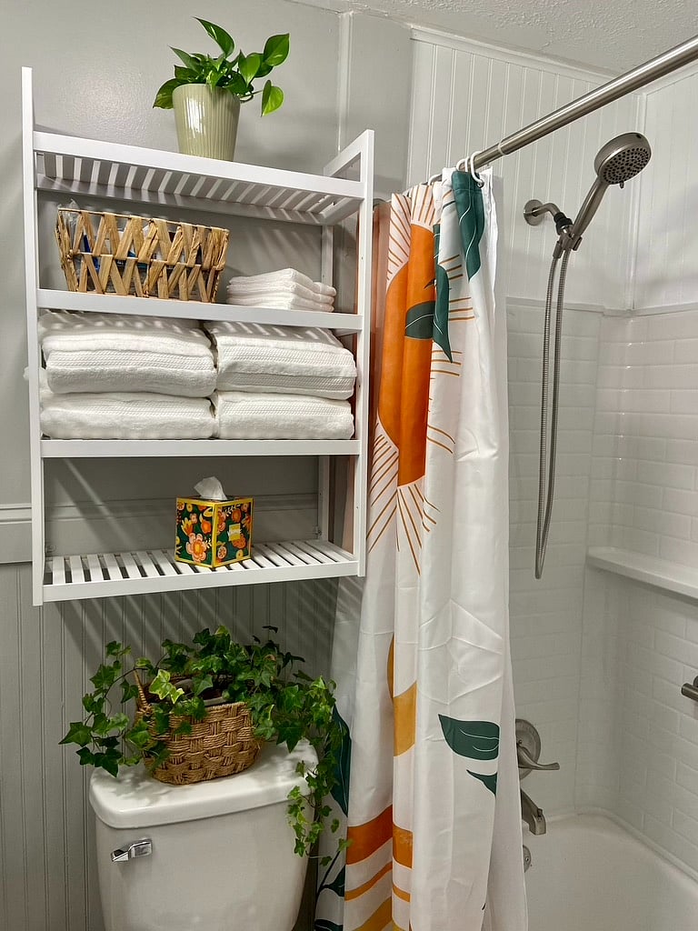 Sparkling new tub surround, new shower fixtures, new lighting, new storage shelves, new tile floor, fluffy fresh towels.