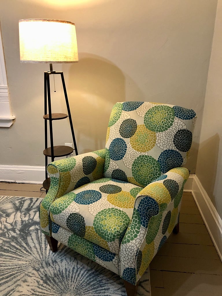 The La-Z-boy reclines for the perfect reading getaway and the nearby lamp has shelves for your beverage and phone.
