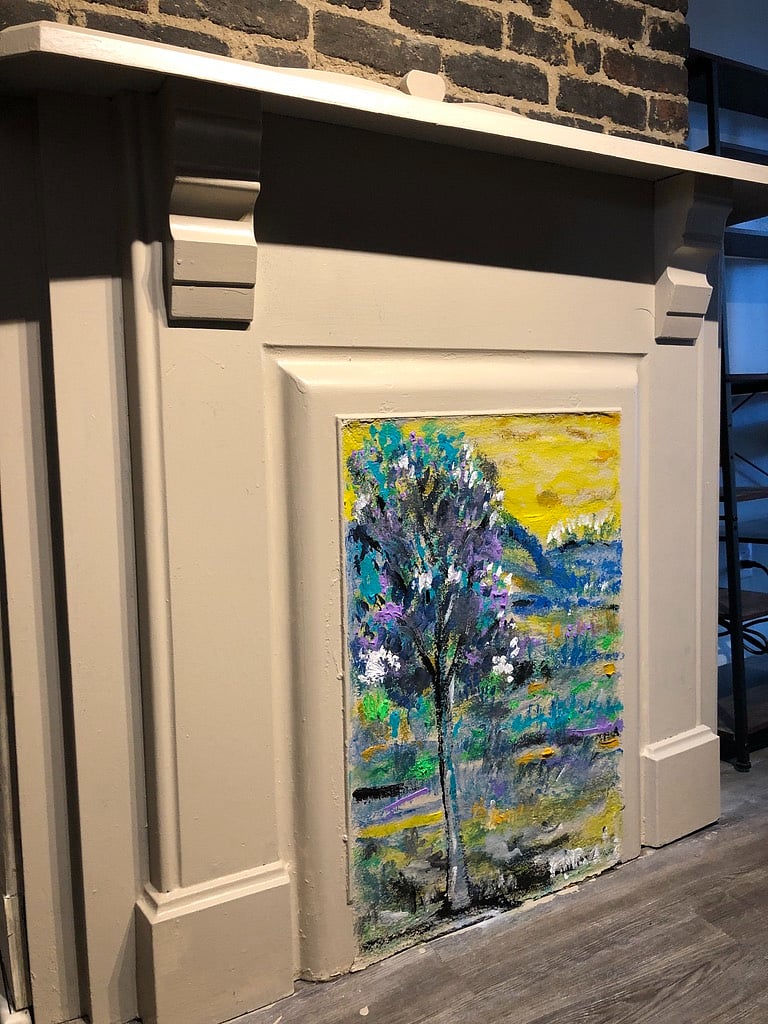 Fireplace #3 of 4 is in the kitchen, The mini-mural (painted in 2024 by local artist Enrique Gonzalez) depicts a mulberry tree, a nod to the street's name at the time the house was built - Mulberry Street.
