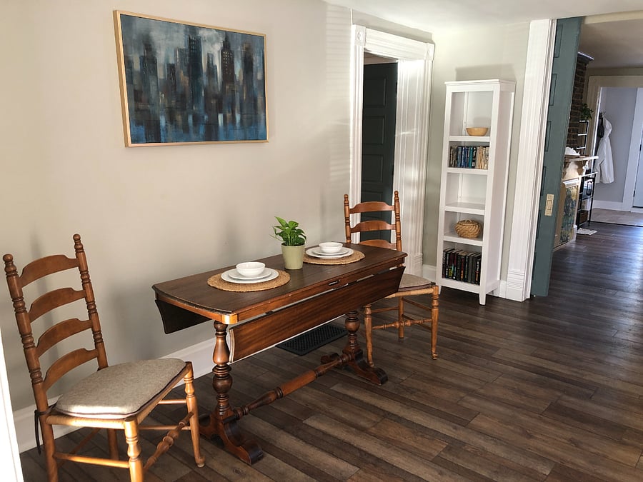 Dining room is situated between the kitchen and living room. Antique trestle table unfolds to seat 4 comfortably. 2 additional dining chairs are provided. 