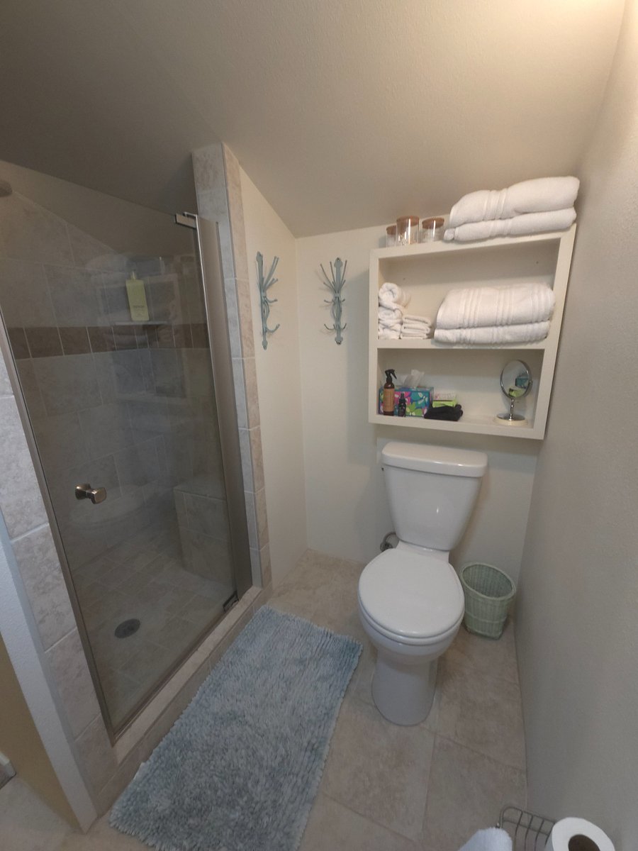 Roomy bathroom, tiled walk in shower with corner seat.