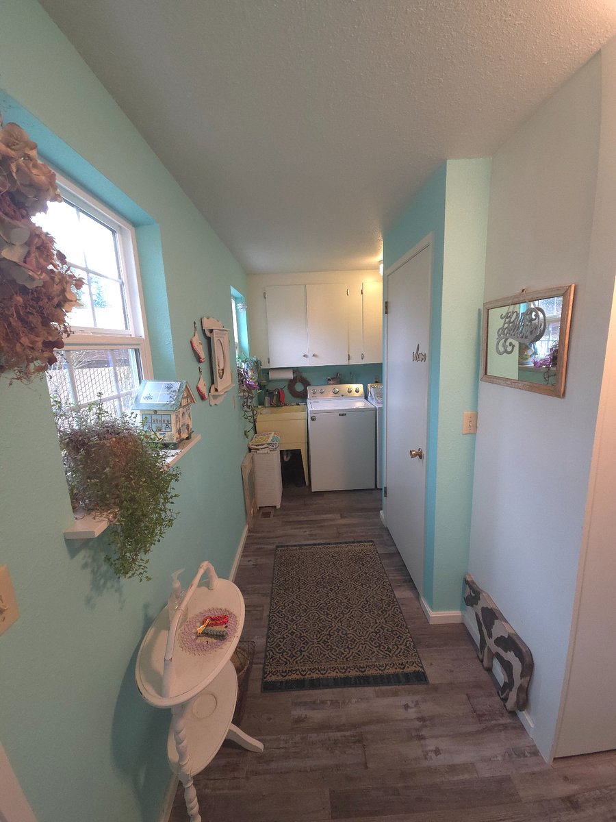 Entrance at exterior door, laundry room, door on right leads upstairs to unit.