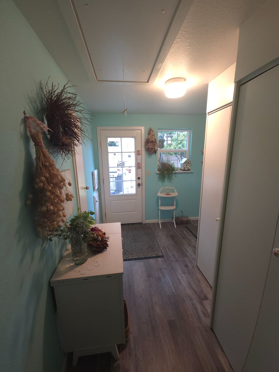 Entrance door from covered patio, ironing board on wall to left.