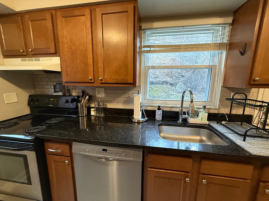 sleek stone counter top
all cooking utensils stored in the metal countainer, paper towel rack, soap dispenser, and dish rack pictured