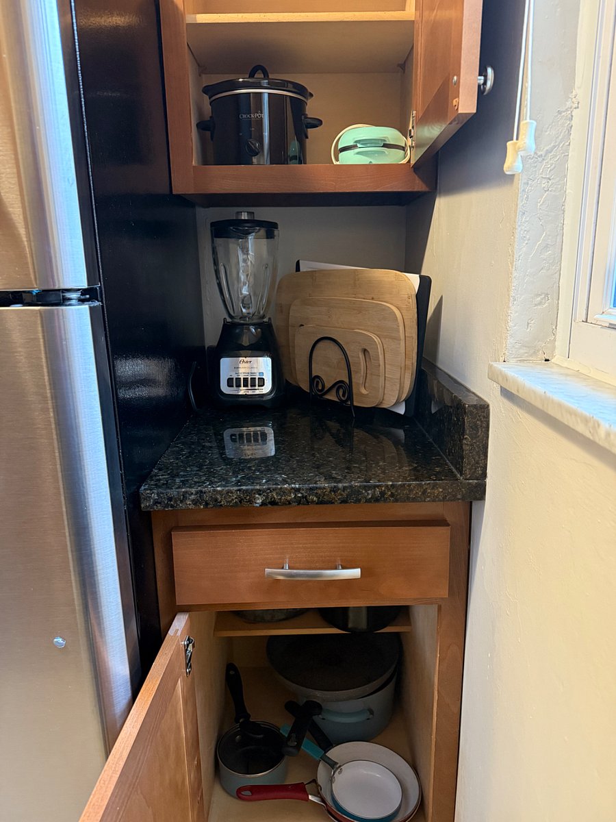 blender, cutting boards on counter
pots and pans below
crockpot and mini griddle in cabinet above