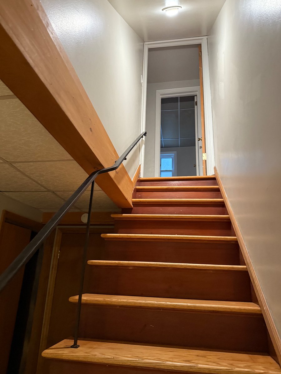 basement stairs to first floor, half bathroom pictured at the top