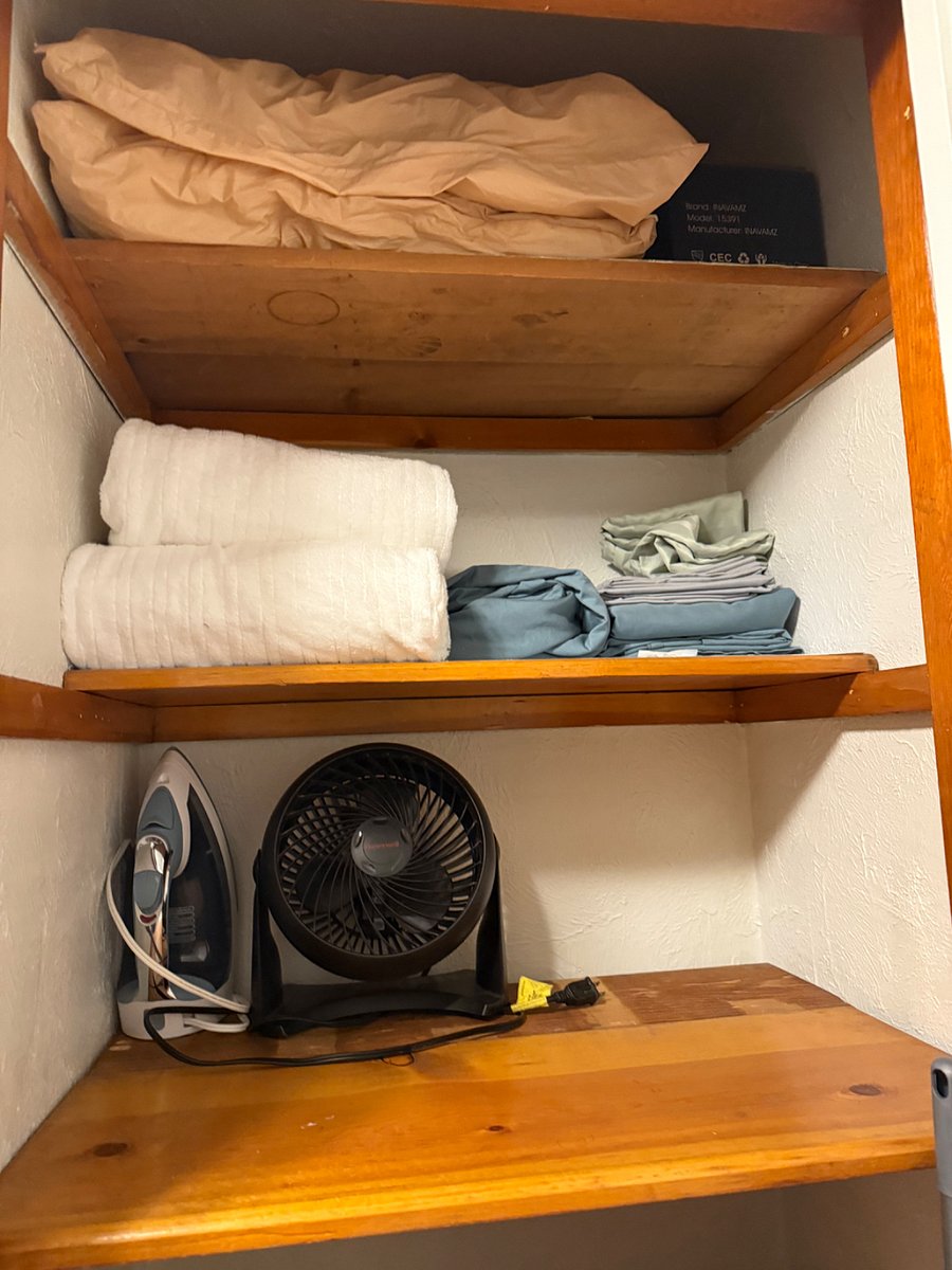 closet atop the stairs to the second floor, stocked with an iron, extra broom, fan, extra sheets, pillowcases and extra pillos