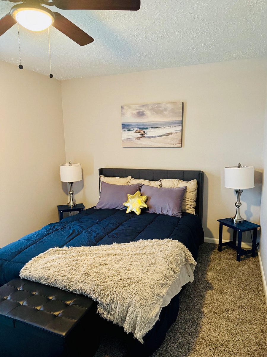 Front bedroom with a queen bed, closet, small dresser, and desk. 